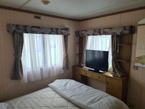 a bedroom with a bed and a flat screen tv at 4 Berth Golden Sands Ingoldmells (Siesta) in Ingoldmells