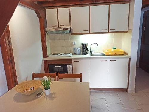 a small kitchen with white cabinets and a table at Panorama Apartments in Asos