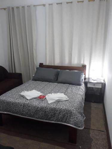 1 dormitorio con 1 cama con 2 toallas en APARTAMENTOS POR DIÁRIA Av DOMINGOS DE ALMEIDA en Pelotas