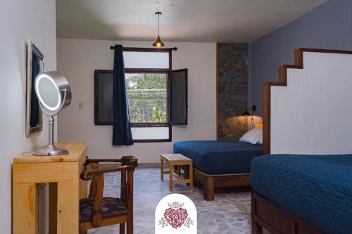 1 dormitorio con cama, silla y espejo en Hotel Corazón de Plata Centro en Guanajuato