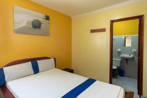 a bedroom with a bed and a bathroom with a sink at Hotel Costa mar in Barranquilla