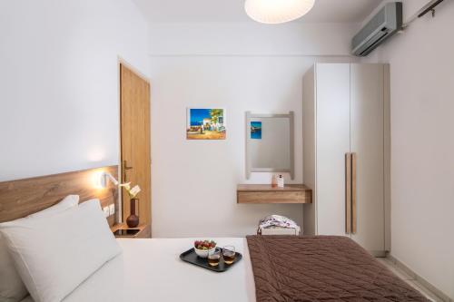 a bedroom with a white bed and a white refrigerator at Belvedere Village in Agia Pelagia