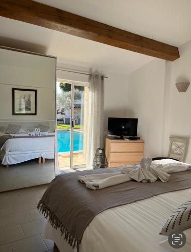une chambre avec un grand lit et une télévision dans l'établissement Villa Made, à Saint-Tropez