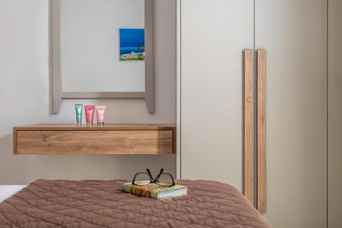 a bedroom with a bed with a book and glasses at Belvedere Village in Agia Pelagia