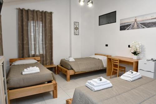 a bedroom with two beds and a desk and a table at La Pineta del Borgo in Ravenna