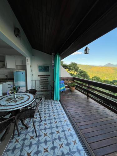 eine Terrasse mit einem Tisch und Stühlen auf einer Terrasse in der Unterkunft Loft com vista ao mar in São Sebastião