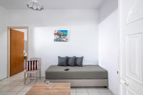 a bedroom with a bed and a chair and a table at Belvedere Village in Agia Pelagia