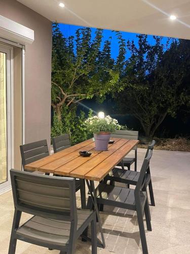 a wooden table and chairs in a patio at M & F HOUSE (παραλία Μαρκοπούλου Ωρωπού) in Oropós