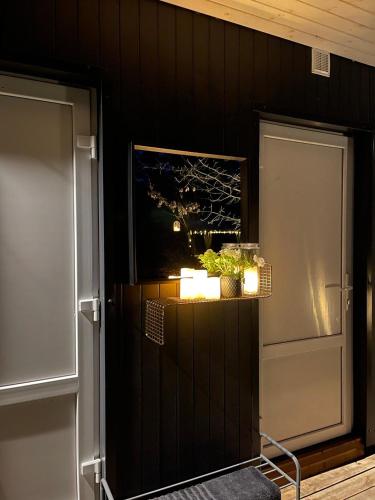 a kitchen with a refrigerator and a table with candles at Camping Milk in Usmenieki