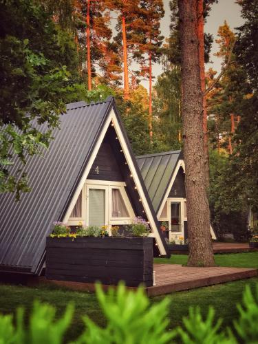 a tiny house with a gray roof and a window at Camping Milk in Usmenieki