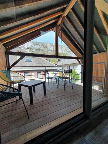 un patio avec une table et des chaises sur une terrasse dans l'établissement La maison du lac, à Doussard