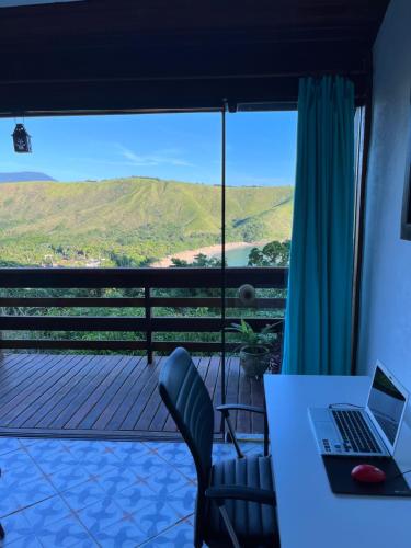 Una computadora portátil sobre una mesa en un balcón. en Loft Mar e Lua, en São Sebastião