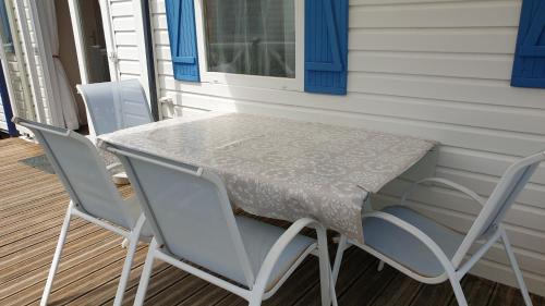 a table and chairs on the porch of a house at Sylvie propriétaire du mobil-home in Saint-Pair-sur-Mer