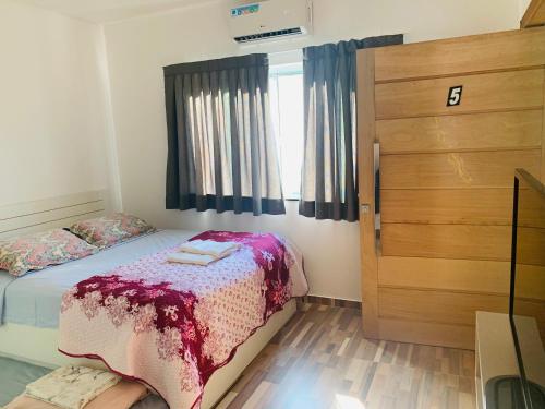 a small bedroom with a bed and a window at Chácara Recanto da Natureza in Foz do Iguaçu