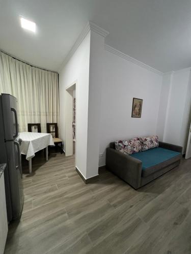 a living room with a couch and a television at Red Rose Guest House in Golem