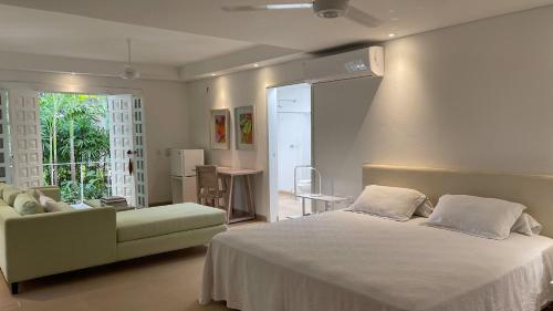 a bedroom with a white bed and a couch at Hotel Boutique Casa Rosalía in Valledupar