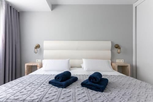 een slaapkamer met een bed met blauwe handdoeken bij Abubilla HolidayFV in Corralejo