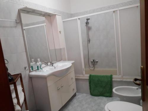 uma casa de banho com um lavatório, um chuveiro e um WC. em Pensiero di mare em Taurisano