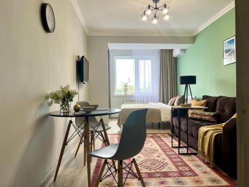 um quarto com uma cama, uma mesa e um sofá em Апартаменты-студия Көктем с видом на город em Almaty