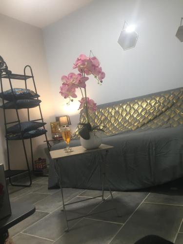 ein Zimmer mit einem Tisch mit einer Vase mit Blumen darauf in der Unterkunft Chez Sandy in Aubagne