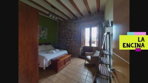 um quarto com uma cama e uma cadeira num quarto em Hostal Rural Ioar em Sorlada