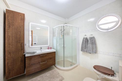a bathroom with a glass shower and a sink at Villa Galasol with heated pool in Radazul
