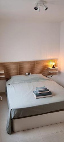een slaapkamer met een groot bed met een hoofdeinde bij duplex appartement met zwembad, L'ampolla, in L'Ampolla