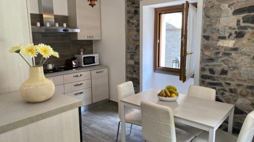 レッツェノにあるDelphina's houseの白いテーブルと花瓶付きのキッチン