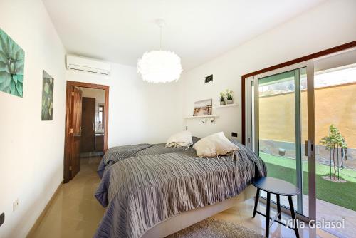 1 dormitorio con cama, mesa y ventana en Villa Galasol with heated pool, en Radazul