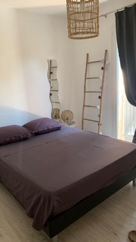 une chambre avec un grand lit avec une couverture violette dans l'établissement Villa en bordure de colline*piscine*clim*netflix, à Les Matelles