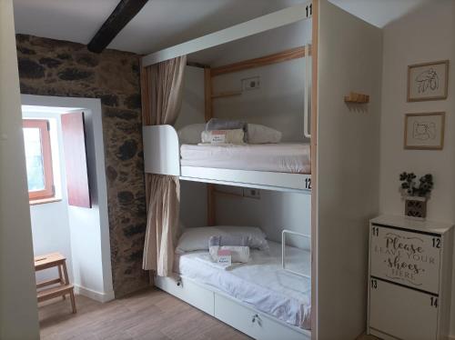 Teo的住宿－Albergue Aldea da Pedreira，一间卧室配有两张双层床。