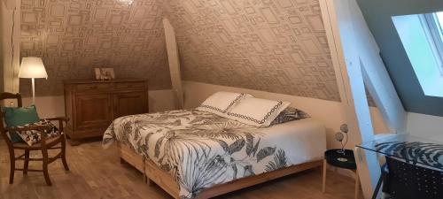 um pequeno quarto com uma cama e uma cadeira em L'escale des caboteurs chambre d'hôte em Saint-Nazaire