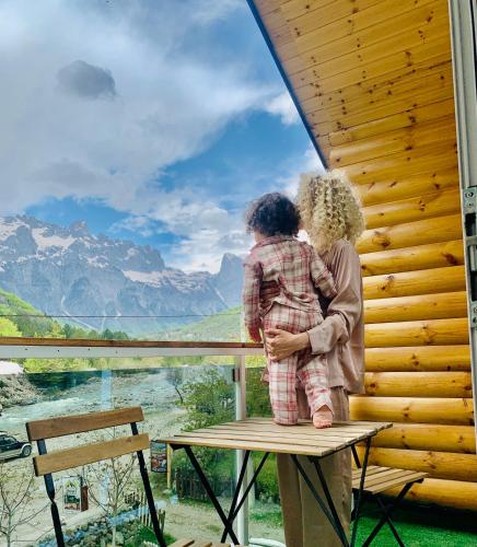 two people standing on a bench looking out at the mountains at Guesthouse Marashi in Theth