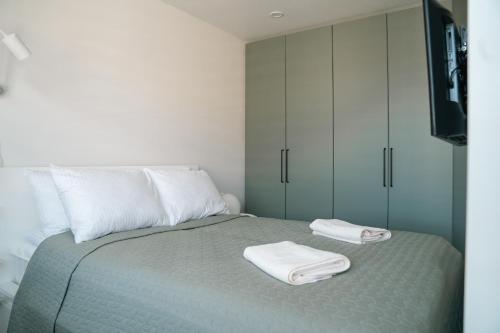 a bedroom with a bed with two towels on it at Grey Green Studio Apartment in Birštonas