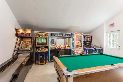 a room with a pool table and arcade machines at Pine Haven in Cape May Court House
