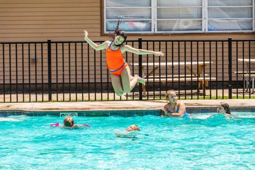 a woman jumping into a swimming pool at Pine Haven in Cape May Court House