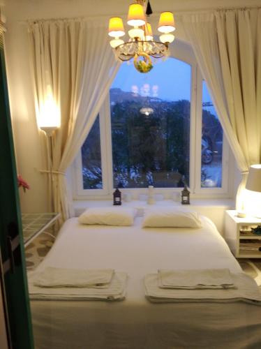 a bedroom with a large white bed with a window at Diles Complex Apartment in Ornos