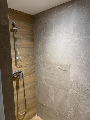 La salle de bains est pourvue d'une douche et d'un mur en pierre. dans l'établissement Trio Marin Mèze, à Mèze