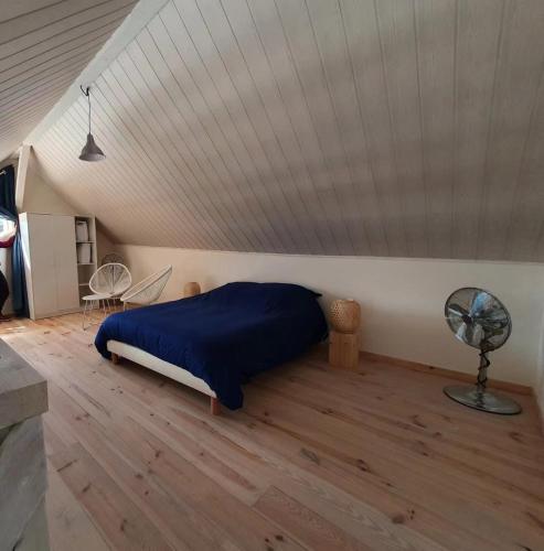 une chambre avec un lit et un parquet dans l'établissement La maison du lac, à Doussard