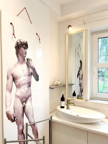 a bathroom with a naked man on the wall at Casa Mia XIX-w Nadmorski Dom z ogrodem in Cedry Małe