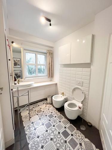 a white bathroom with a toilet and a sink at Casa Mia XIX-w Nadmorski Dom z ogrodem in Cedry Małe
