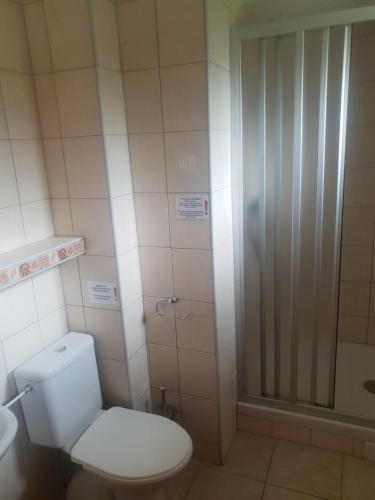 La salle de bains est pourvue d'une douche et de toilettes. dans l'établissement Holiday Village Tatralandia Bungalov 3-2-2 chatka 431 s 1 spálňou 1 obývačkou a 1 izbou v podkrovi, à Liptovský Mikuláš