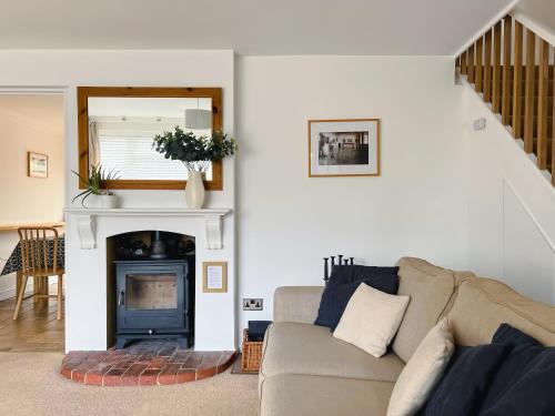 a living room with a couch and a fireplace at Bright & Cosy - Jacuzzi - Log Burner - King Beds in Tangmere