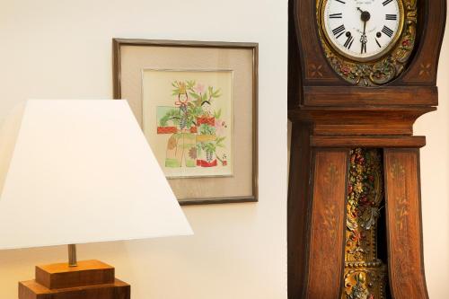 a grandfather clock sitting next to a lamp and a lampost at Hôtel du Cygne Paris in Paris