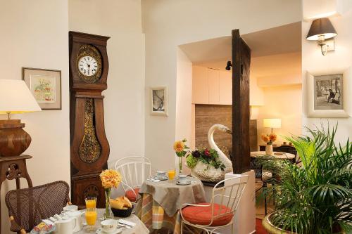 a dining room with a table and a grandfather clock at Hôtel du Cygne Paris in Paris