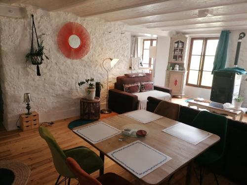 a living room with a table and a couch at La Grange en Champagne in Hermonville