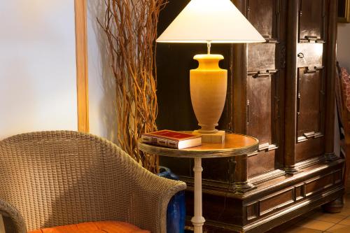 a lamp sitting on a table next to a chair at Hôtel du Cygne Paris in Paris