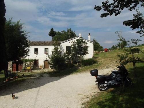 een motorfiets geparkeerd voor een wit huis bij Agriturismo Masseria Testa Ciruglio in Ielsi