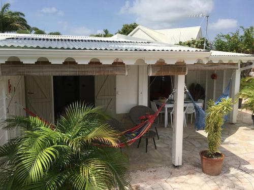 a house with a hammock in front of it at Villa avec piscine privée in Saint-François