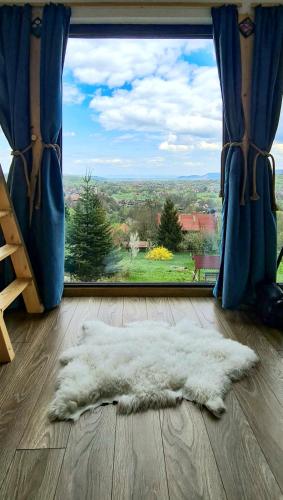 a white rug on the floor in front of a window at Tiny House Retreat Bran in Bran
